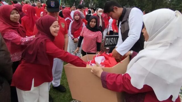 ASN Pemkot Depok mengenakan pakaian olahraga merah putih saat apel pengumpulan bendera Merah Putih di Balai Kota