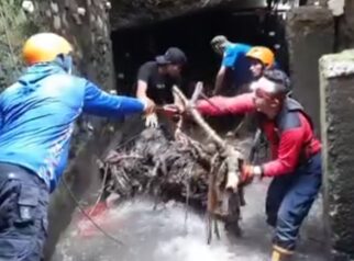 Petugas Damkar Depok menyusuri gorong-gorong Jalan Alternatif Cibubur untuk mengangkat sampah dan pohon penyebab banjir.