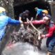 Petugas Damkar Depok menyusuri gorong-gorong Jalan Alternatif Cibubur untuk mengangkat sampah dan pohon penyebab banjir.