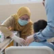 Petugas Puskesmas Depok melakukan cek kesehatan gratis kepada siswa di sekolah dasar